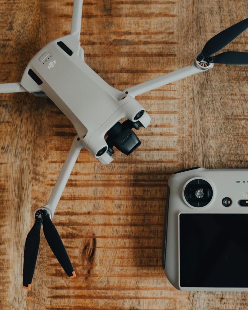 Top view of a drone and controller set on a rustic wooden surface, showcasing modern technology.